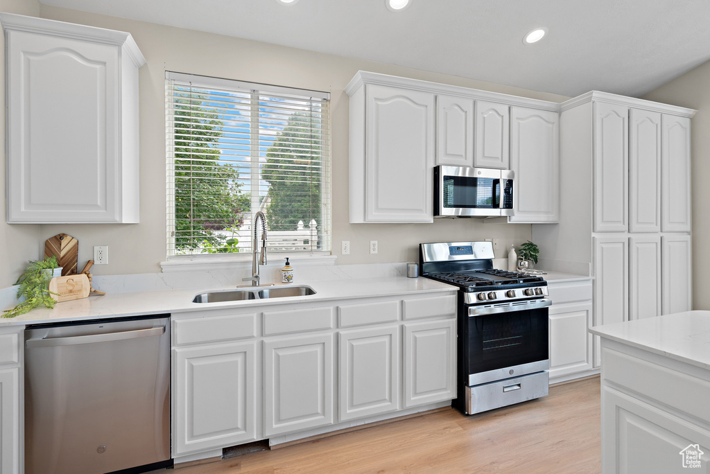 Kitchen featuring stainless steel appliances, plenty of natural light, recessed lighting, and white cabinets