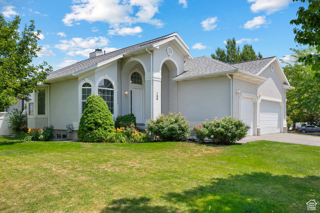 Single story home featuring stucco siding, a garage, and a front yard