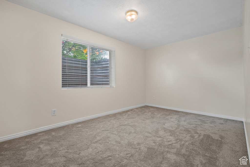 Empty room featuring carpet floors and baseboards