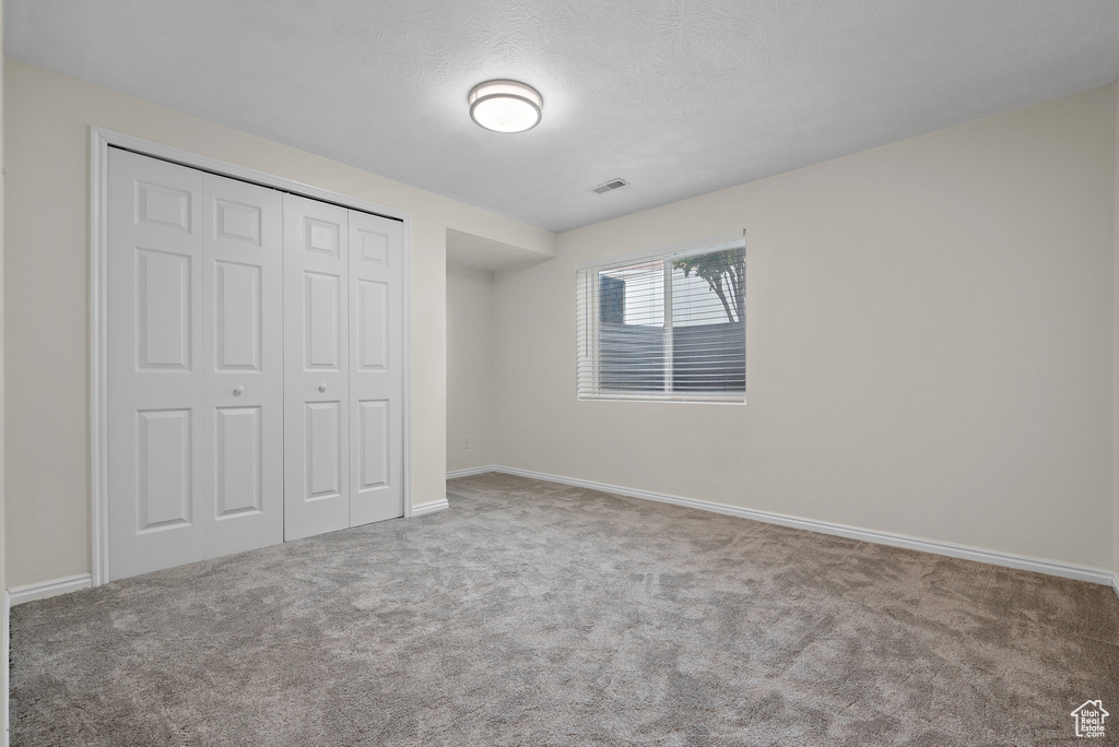 Unfurnished bedroom featuring carpet floors and a closet