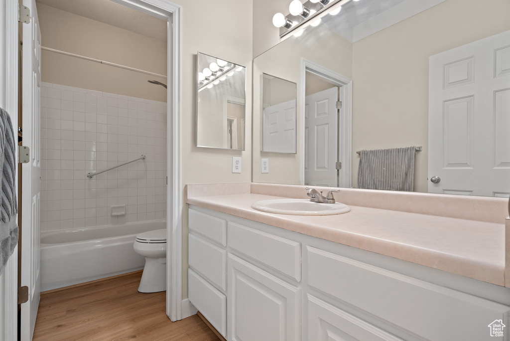 Full bath featuring vanity, wood finished floors, and bathing tub / shower combination