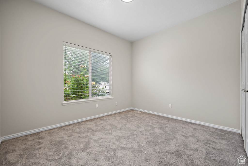 Carpeted empty room with baseboards