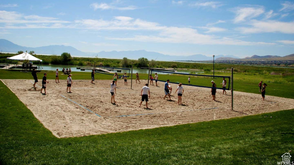 View of community with a yard, volleyball court, and a water and mountain view