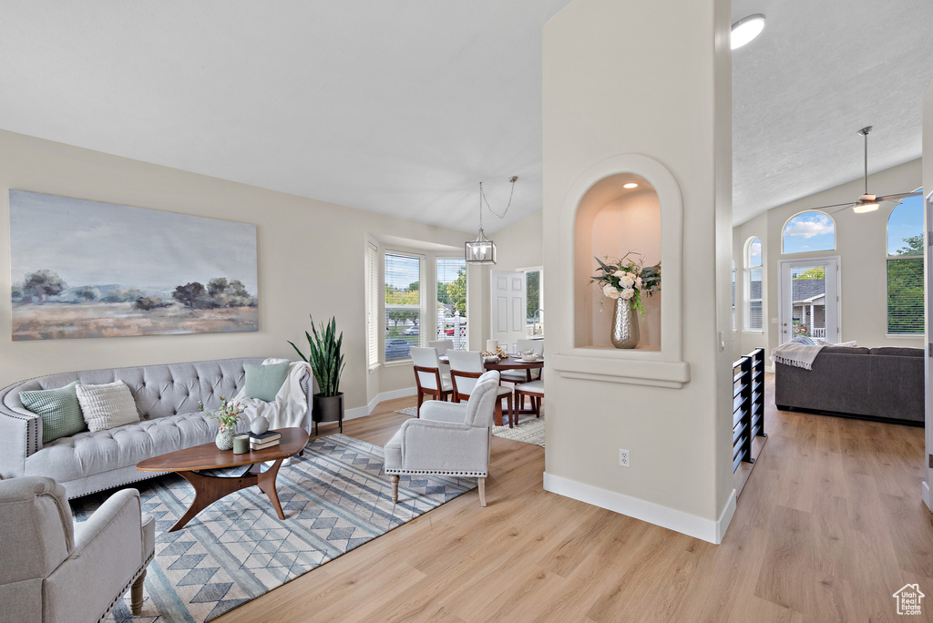 Living area featuring wood finished floors, lofted ceiling, and a ceiling fan