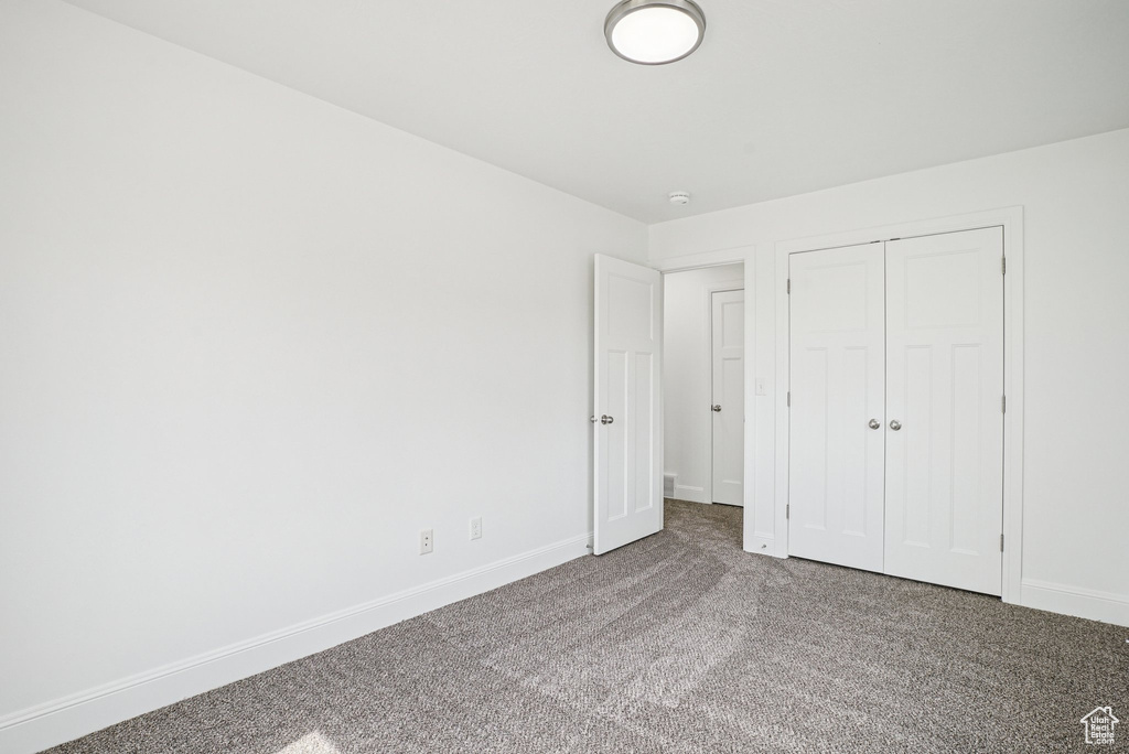 Unfurnished bedroom featuring carpet floors and a closet