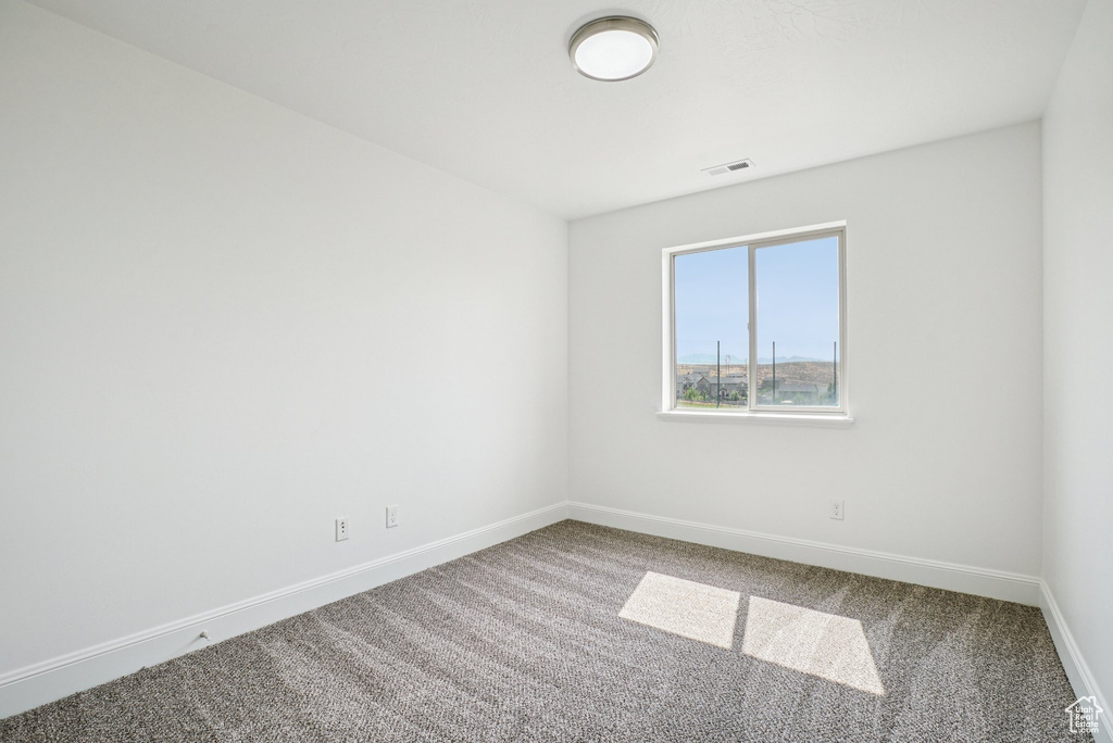 Carpeted empty room with baseboards