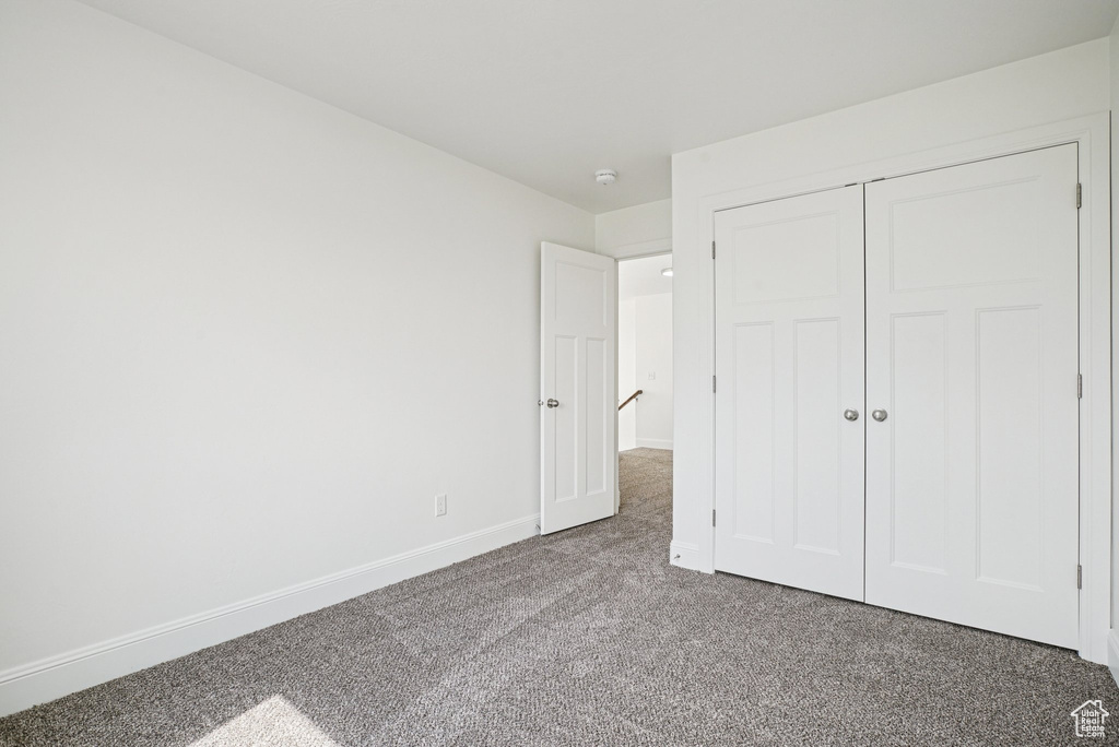 Unfurnished bedroom featuring carpet and a closet