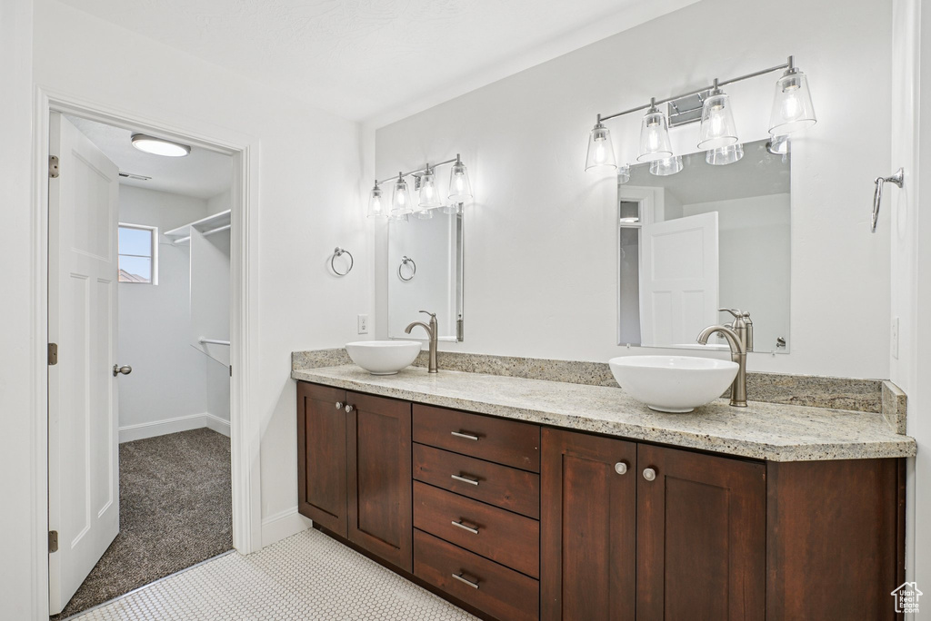 Bathroom featuring double vanity and a spacious closet