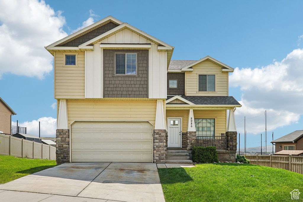 Craftsman-style house featuring stone siding, concrete driveway, covered porch, an attached garage, and a shingled roof