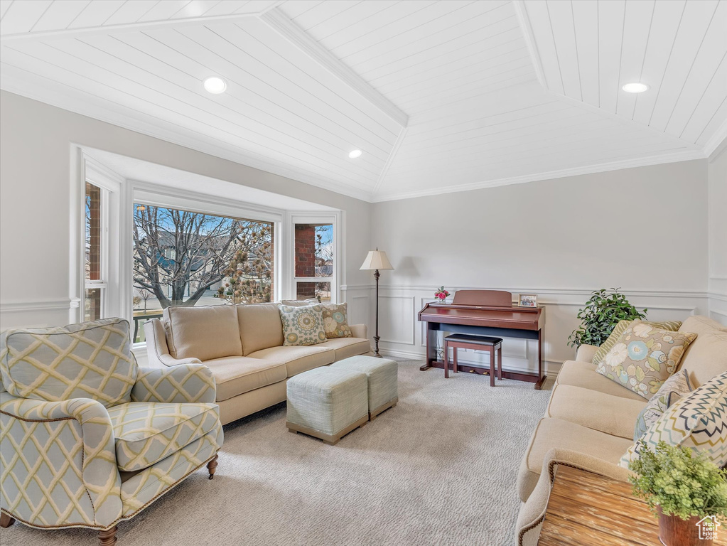 Living area with wainscoting, lofted ceiling, carpet floors, ornamental molding, and recessed lighting