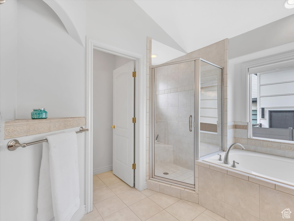 Bathroom featuring a bath, a shower stall, tile patterned flooring, and vaulted ceiling