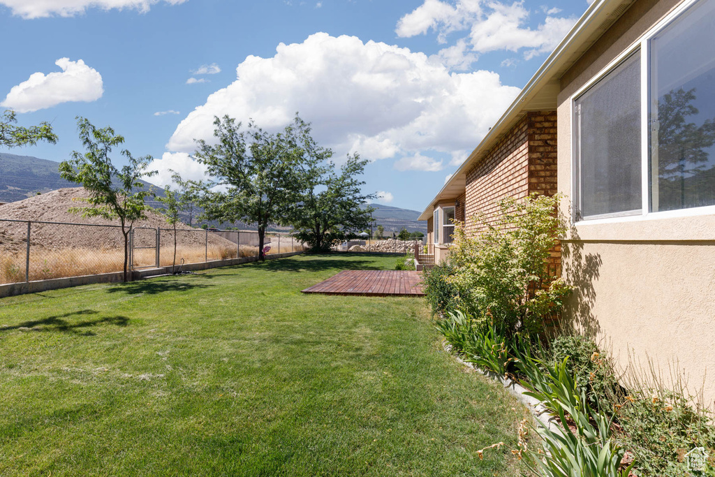 View of yard featuring a deck with mountain view