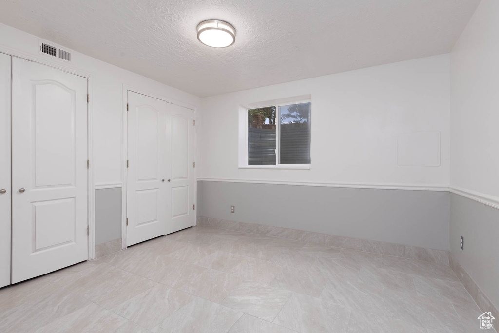 Unfurnished bedroom with a textured ceiling and baseboards