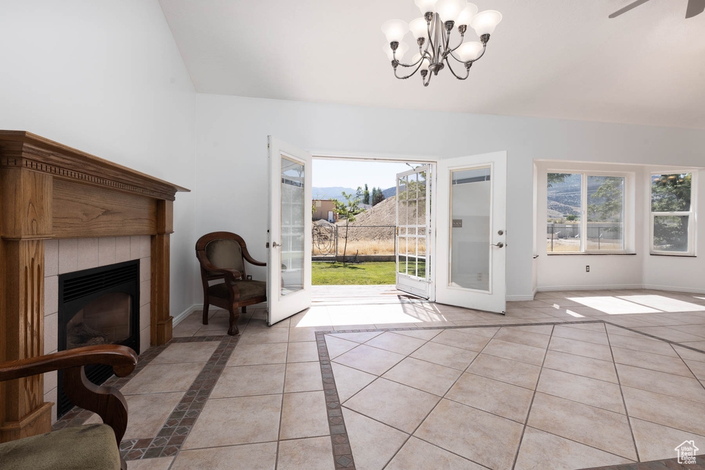 Entryway featuring healthy amount of natural light, a chandelier, a fireplace, and light tile patterned floors