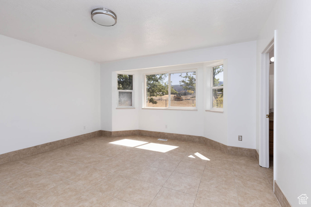 Empty room featuring light tile patterned floors