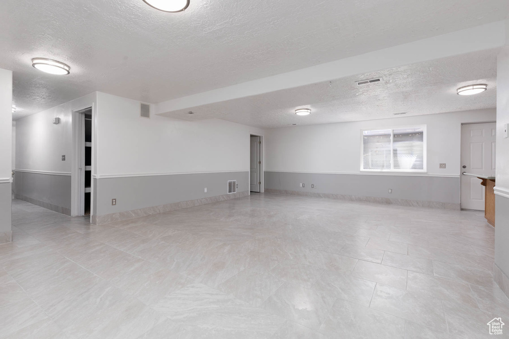 Spare room with a textured ceiling and baseboards