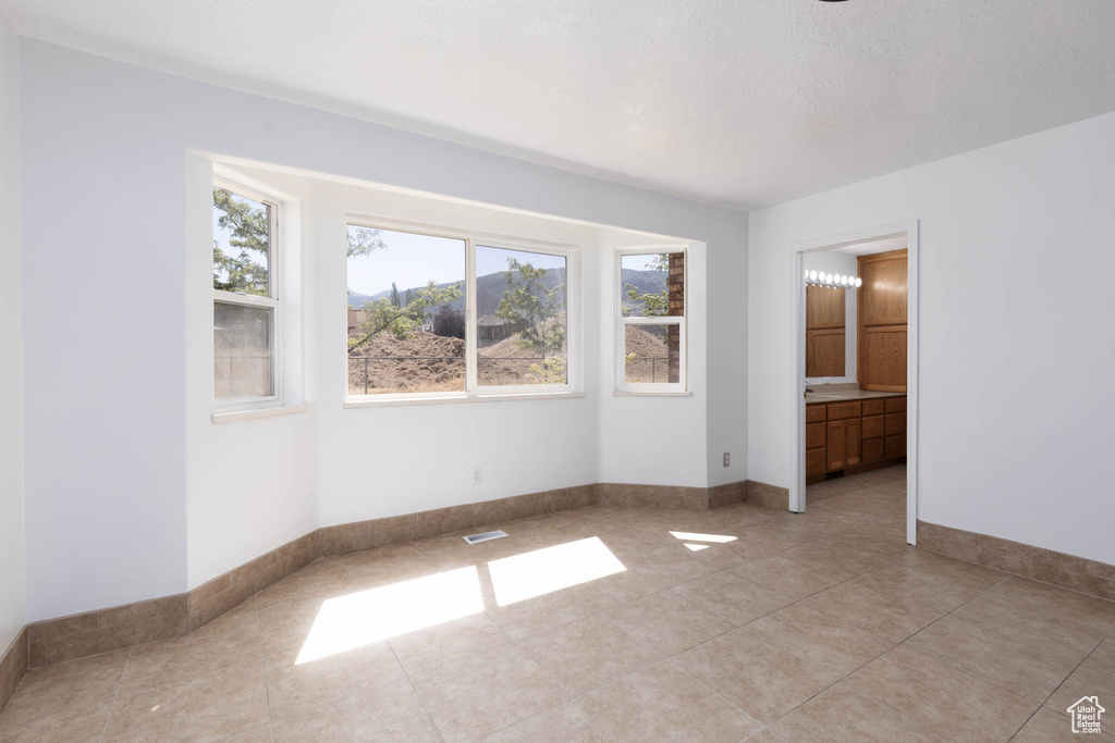 Unfurnished room with light tile patterned floors and baseboards