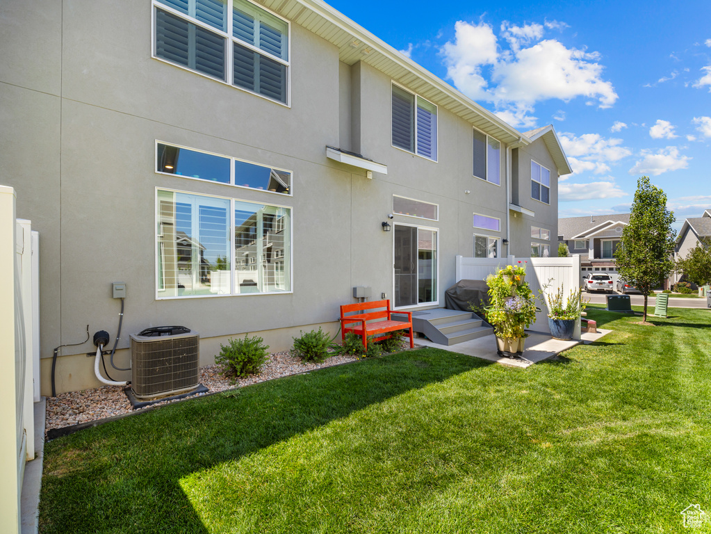 Back of property featuring stucco siding and a lawn