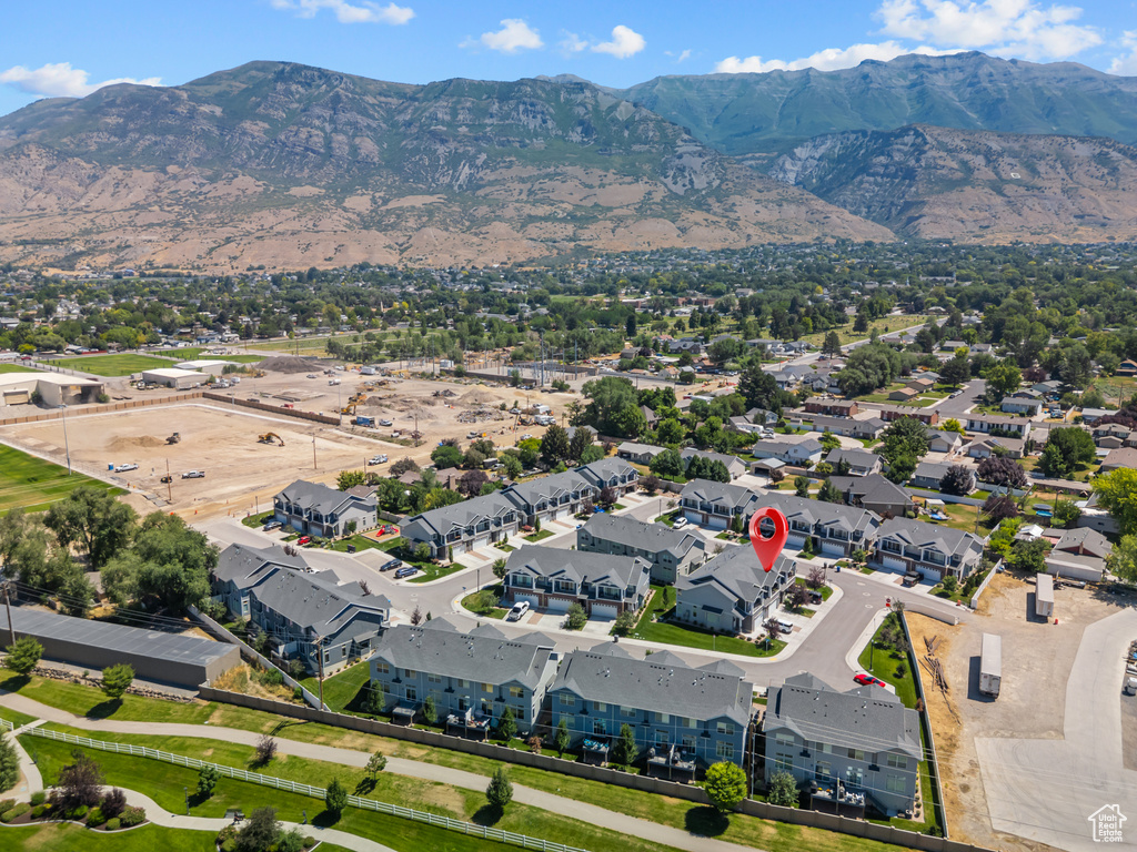 Aerial view of property and surrounding area featuring a mountainous background and nearby suburban area