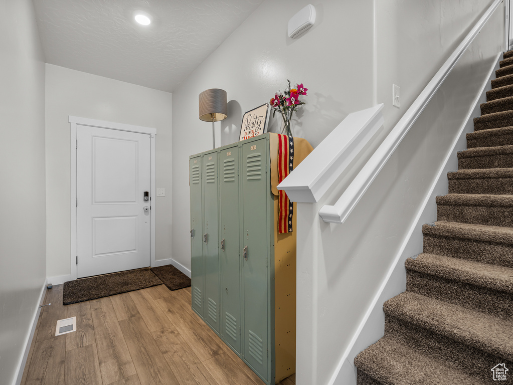 Entrance foyer with stairway, wood finished floors, and recessed lighting
