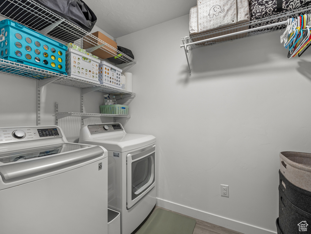 Laundry area featuring washing machine and clothes dryer and wood finished floors