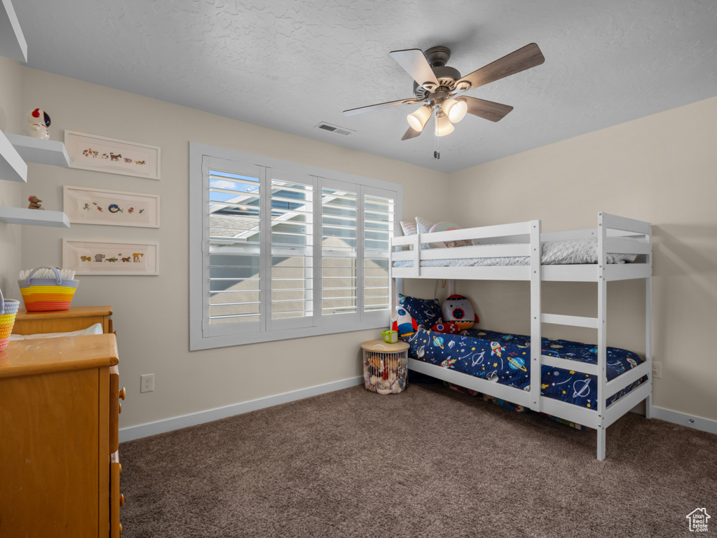 Bedroom with carpet, a ceiling fan, and a textured ceiling