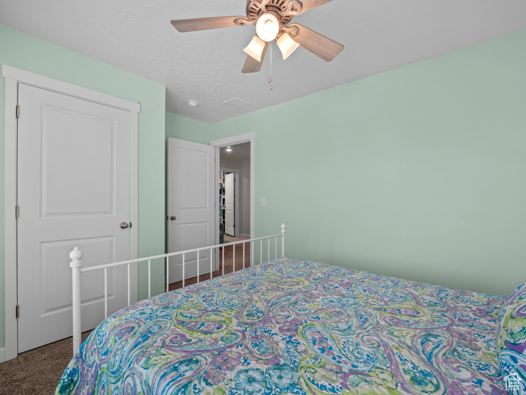 Carpeted bedroom featuring a ceiling fan