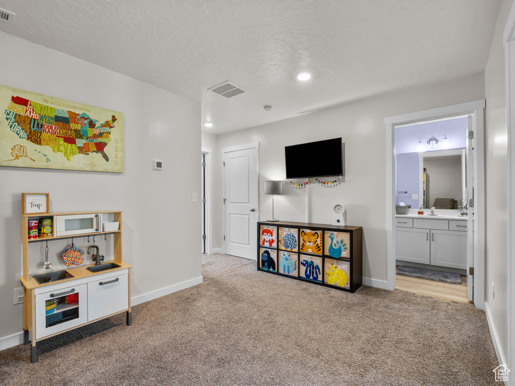 Recreation room featuring carpet floors, a textured ceiling, and recessed lighting