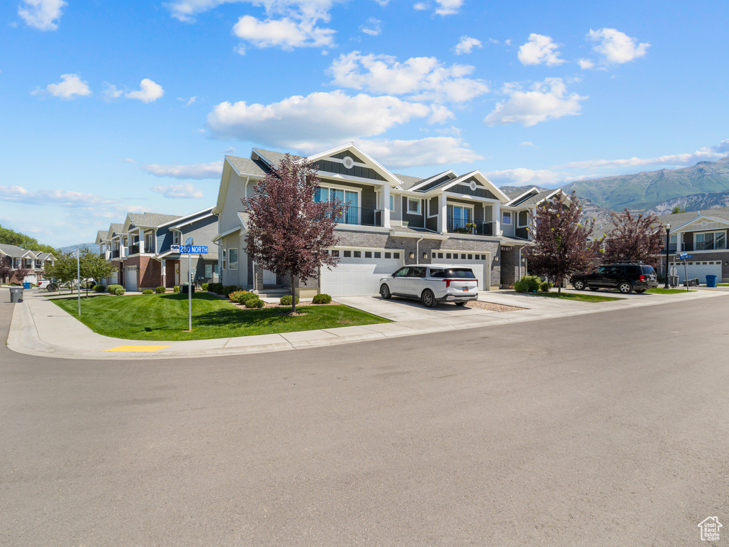 View of front facade with a garage, a residential view, board and batten siding, and concrete driveway