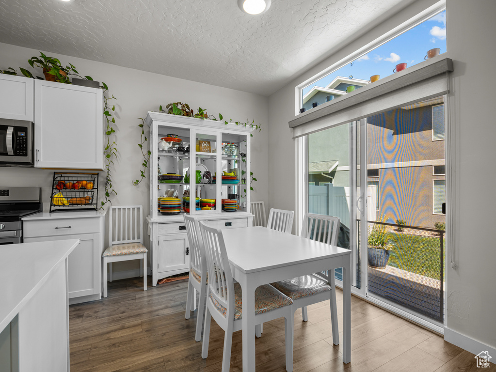 Dining area with a textured ceiling and light wood-style flooring