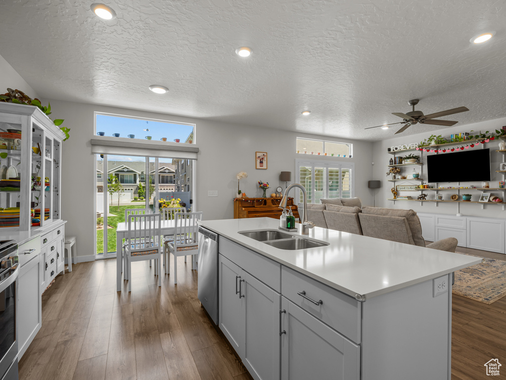 Kitchen with a textured ceiling, a ceiling fan, light countertops, healthy amount of natural light, and open floor plan