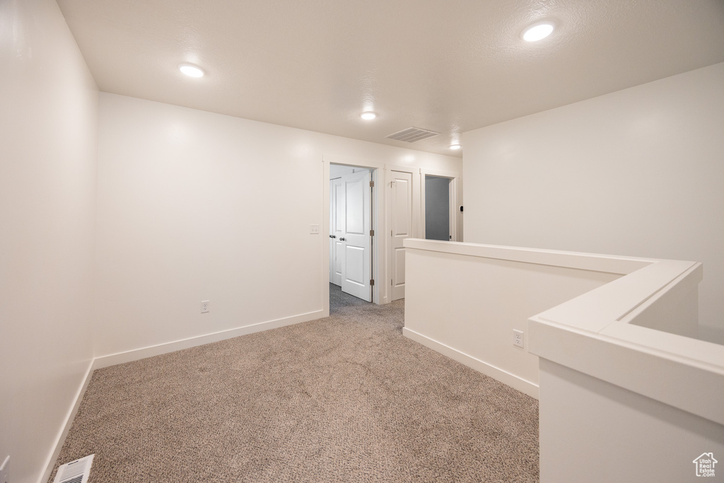 Carpeted empty room with baseboards and recessed lighting