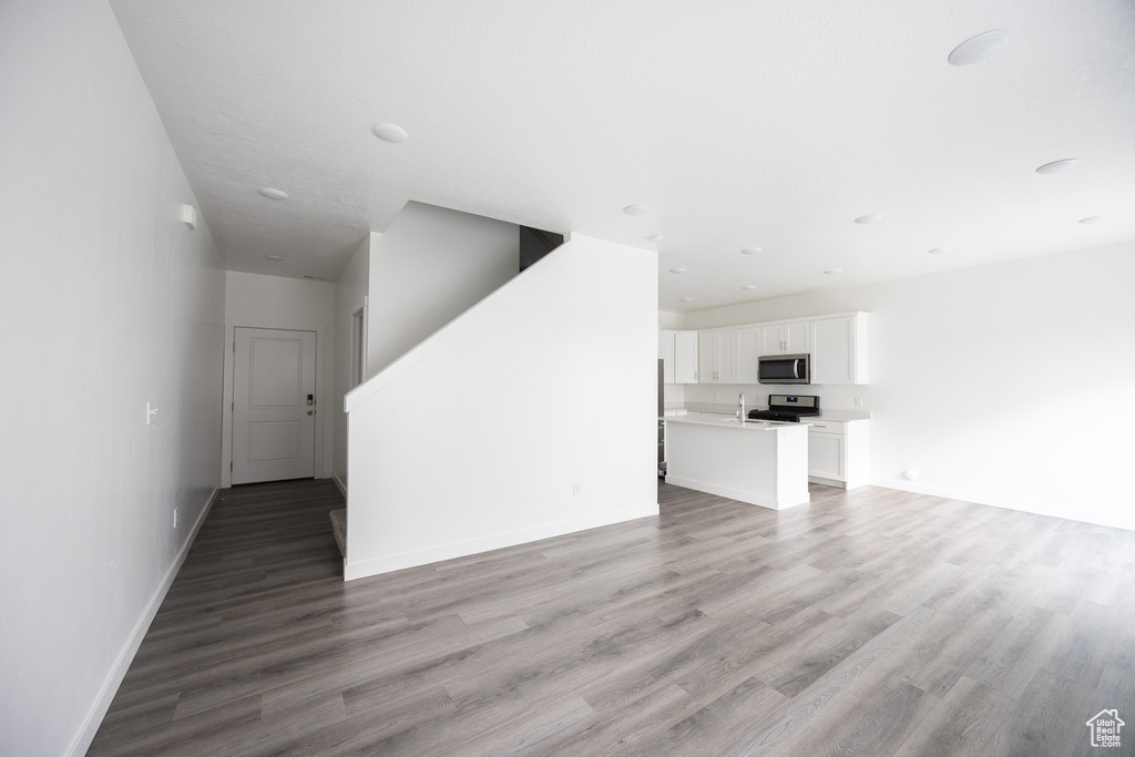 Unfurnished living room featuring light wood-style floors and baseboards