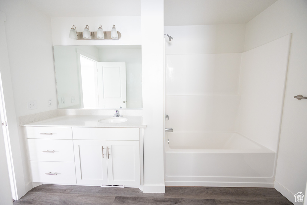 Full bath with vanity, bathtub / shower combination, and wood finished floors