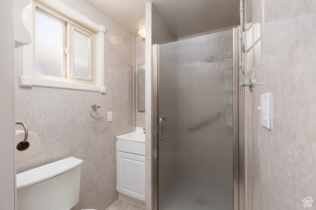 Full bathroom featuring vanity, a stall shower, and tile patterned floors