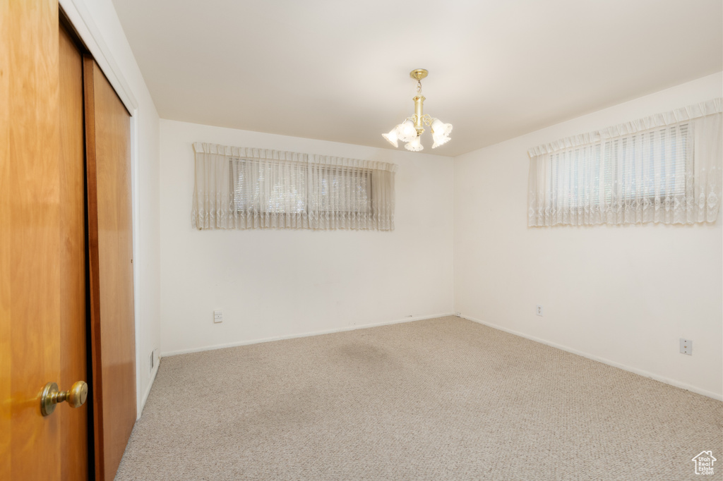 Unfurnished bedroom featuring carpet floors, a chandelier, and a closet