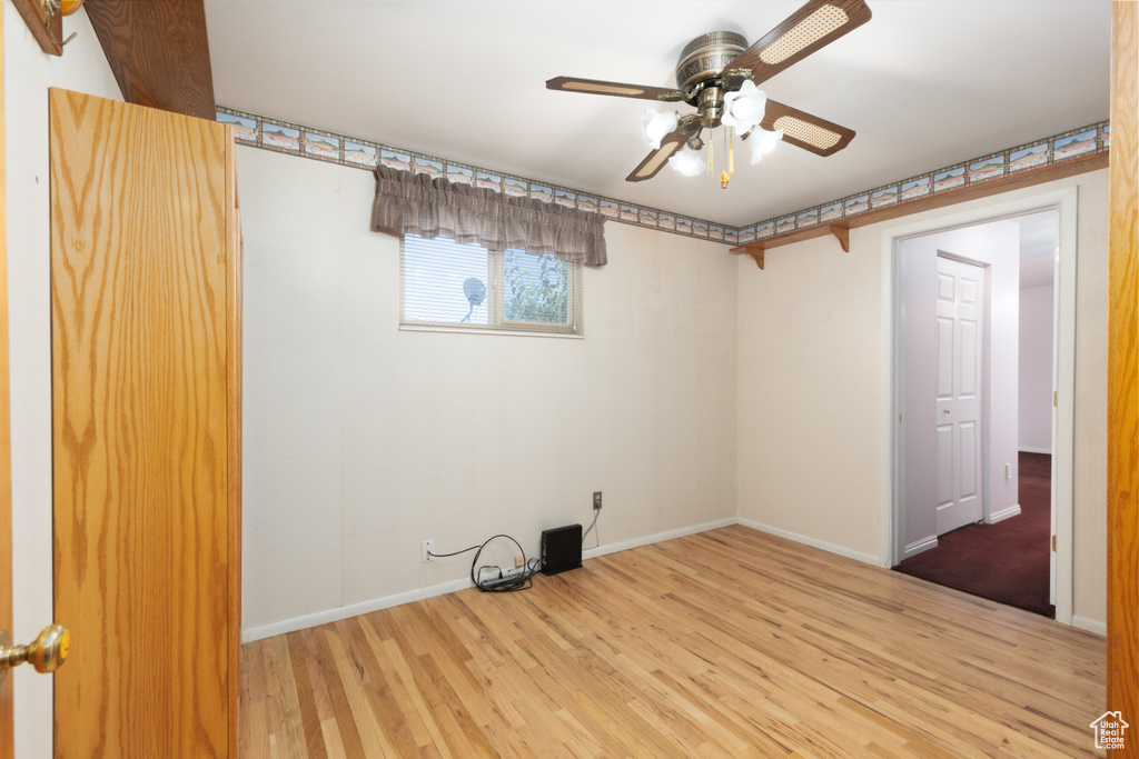 Empty room with wood finished floors and ceiling fan