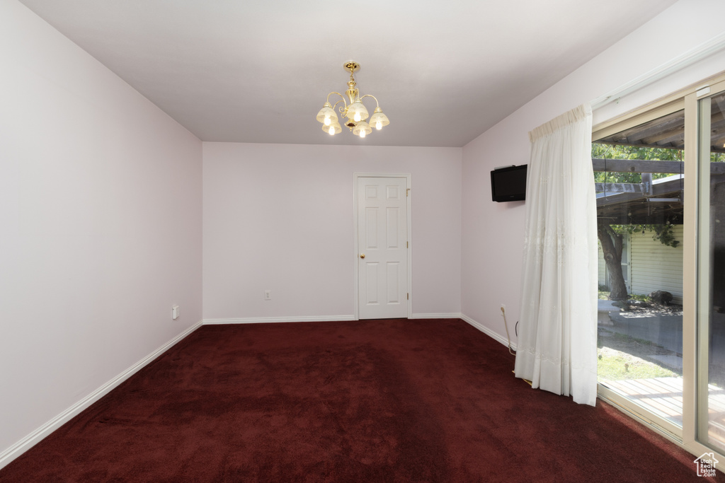 Unfurnished room featuring carpet flooring and a chandelier