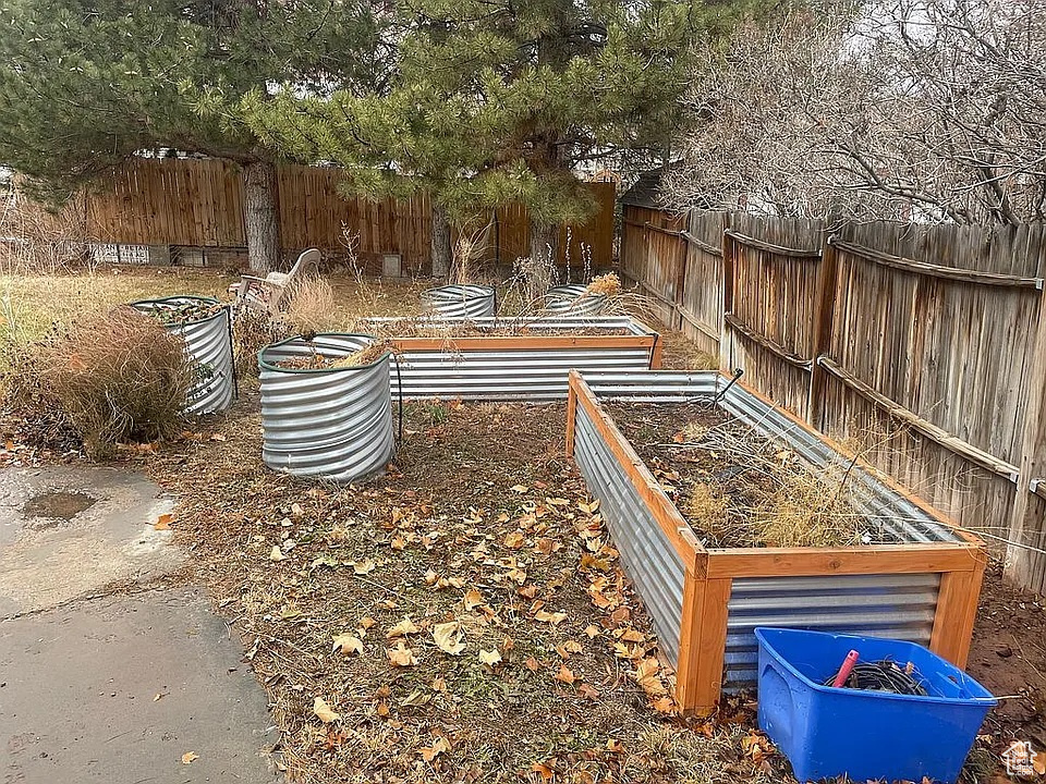 Fenced backyard featuring a garden