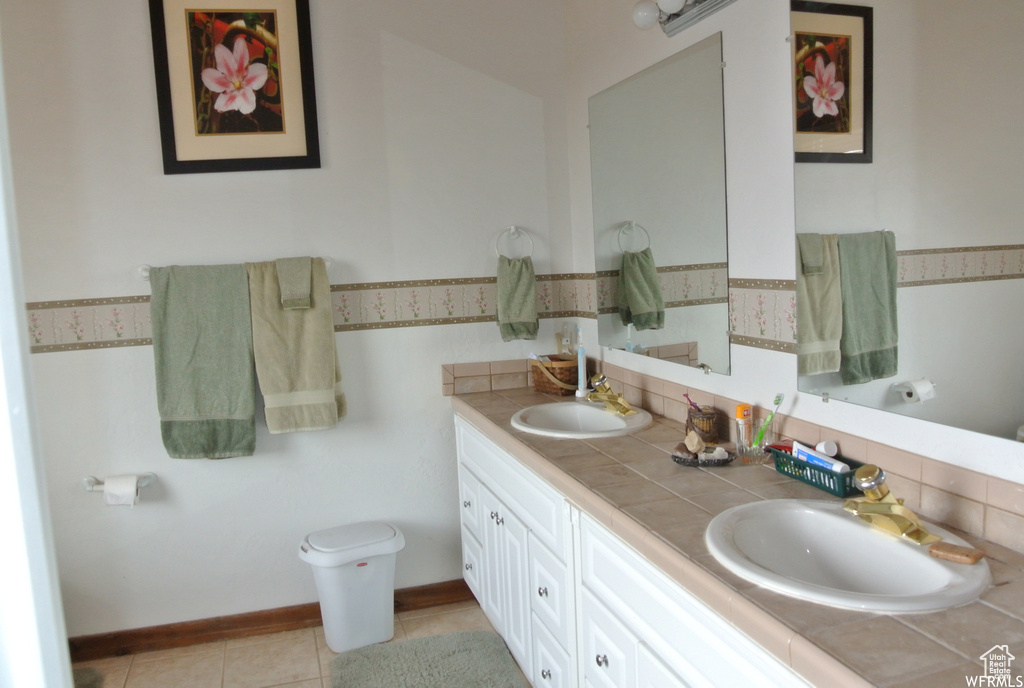 Bathroom with double vanity, backsplash, and tile patterned floors