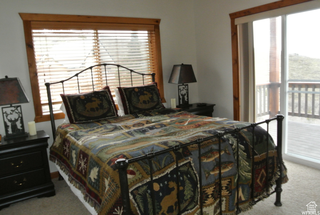 Bedroom featuring carpet, multiple windows, and access to exterior