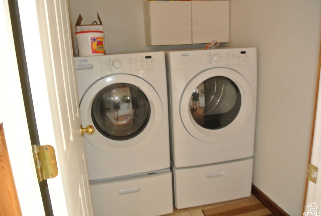 Laundry area featuring washing machine and clothes dryer and cabinet space