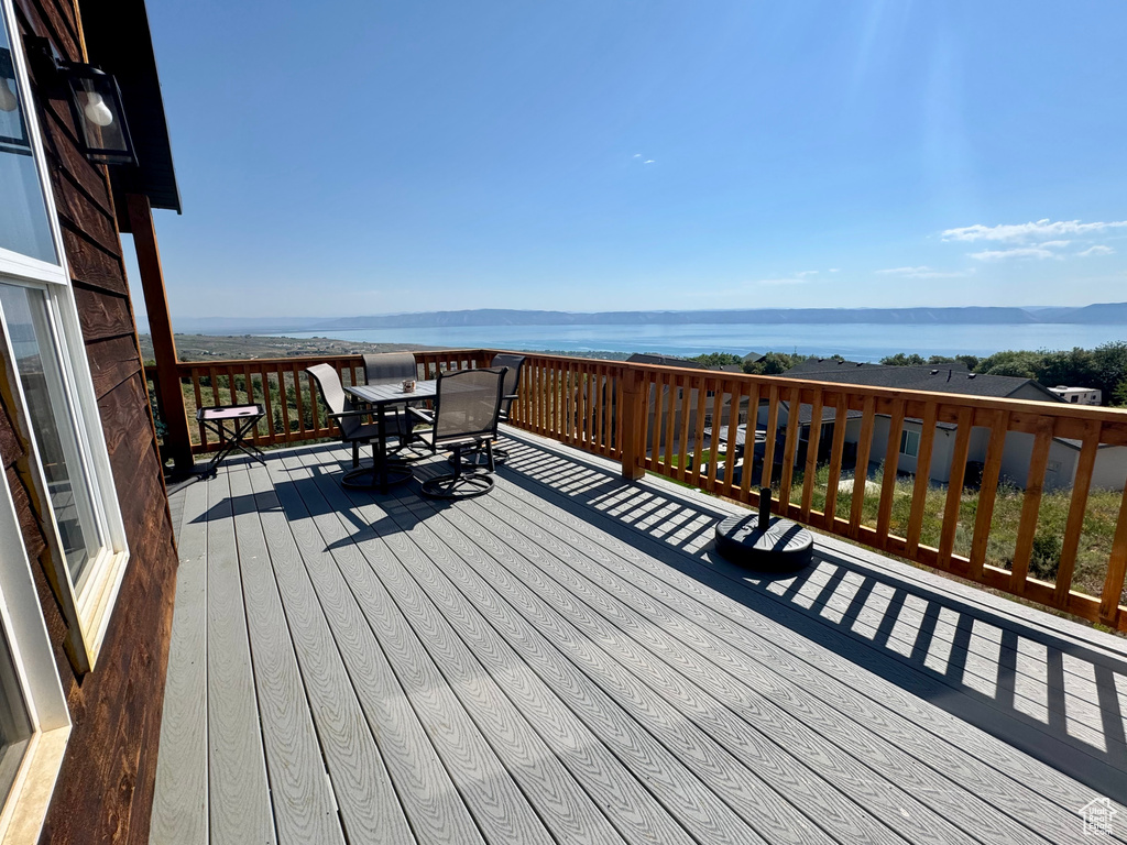 Wooden deck featuring outdoor dining area and a water view