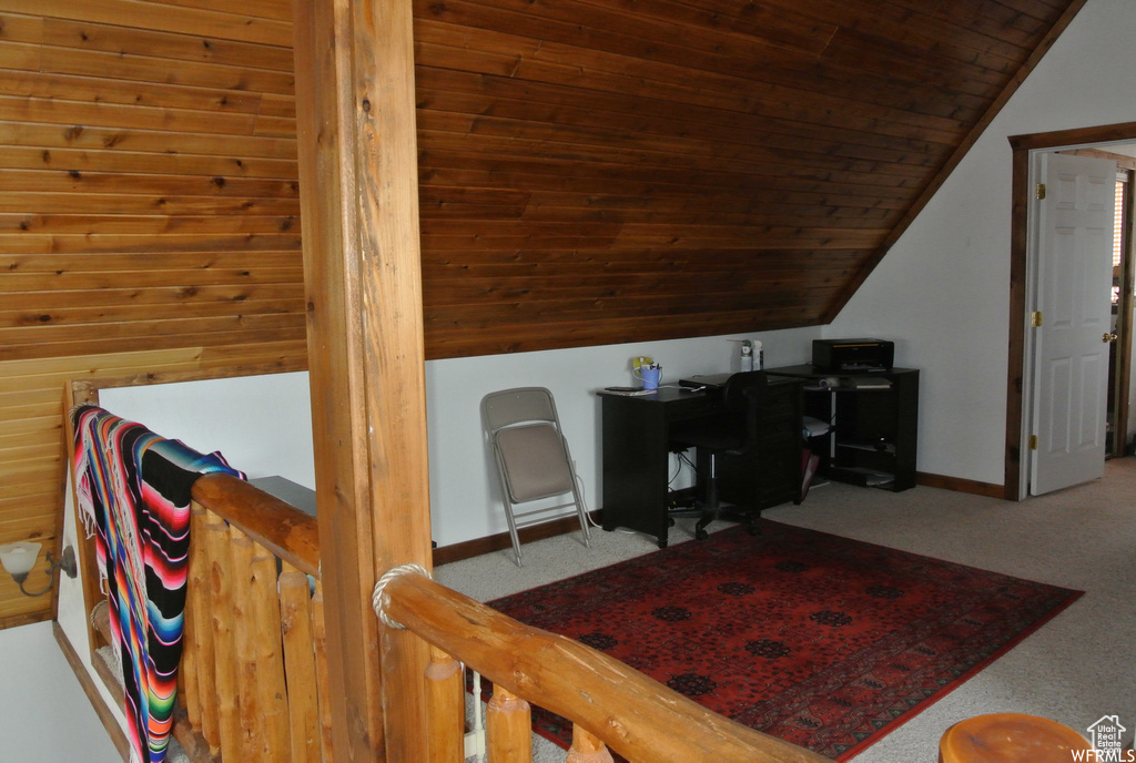 Home office with vaulted ceiling, carpet flooring, and wooden ceiling