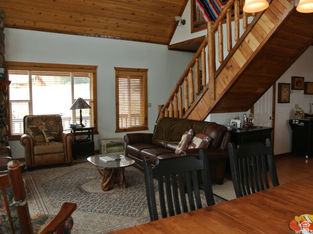 Living room featuring lofted ceiling, wooden ceiling, stairs, and wood finished floors