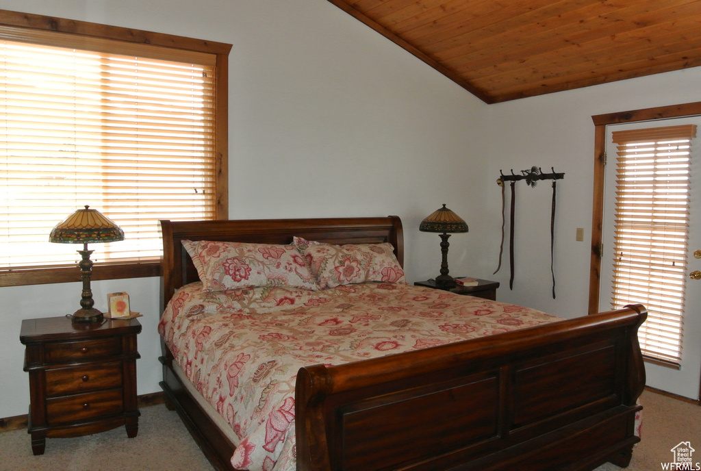 Bedroom with light colored carpet, vaulted ceiling, wooden ceiling, and multiple windows