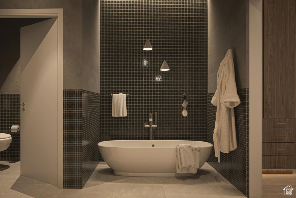 Full bath with tile walls and a freestanding tub