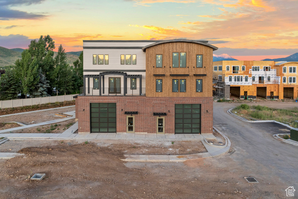 View of building exterior with an attached garage, a mountain view, and driveway