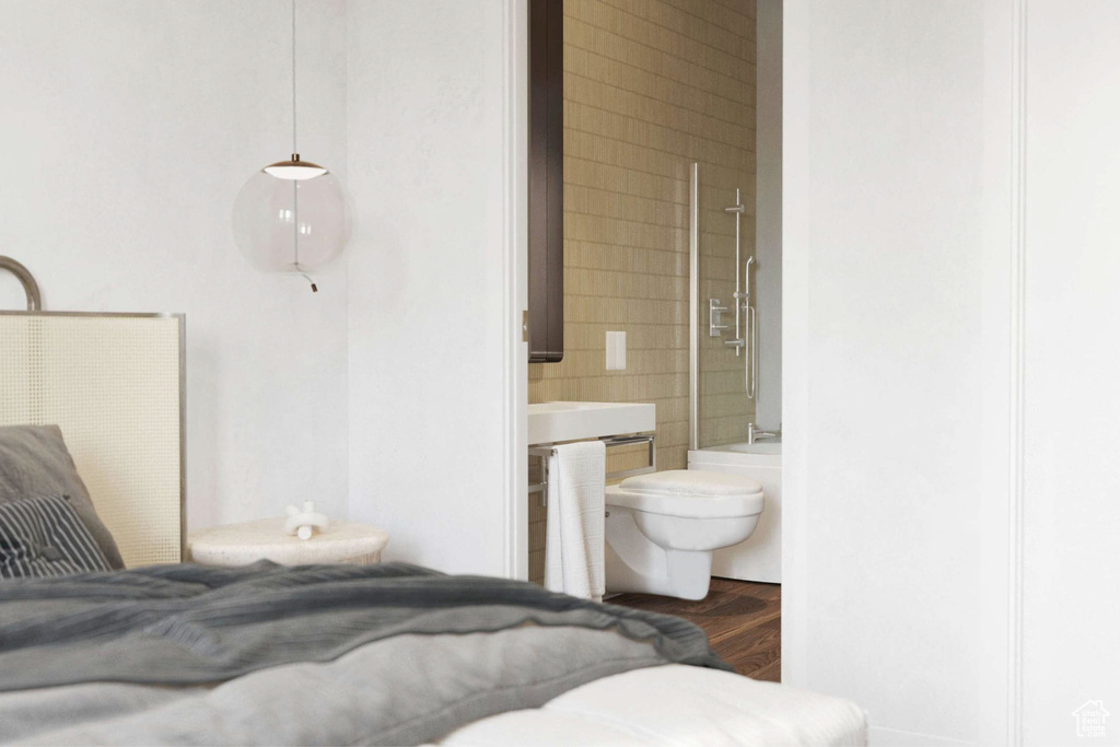Bedroom featuring ensuite bath and wood finished floors