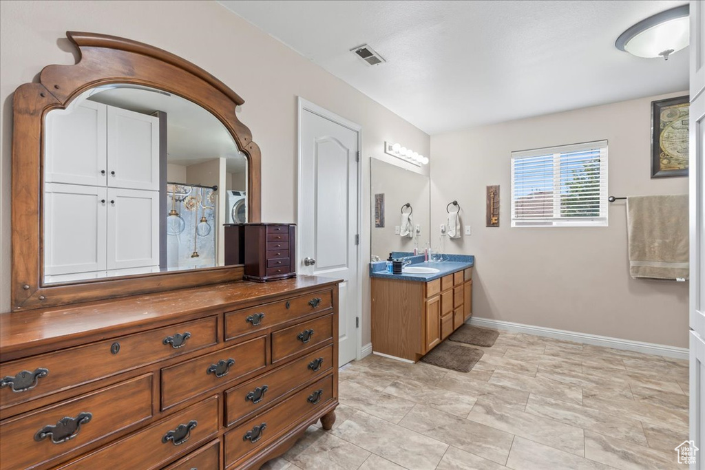 Full bathroom with vanity and baseboards